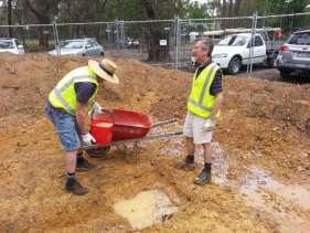 Two Shed members doing site preparation work in muddy conditions, January 2018