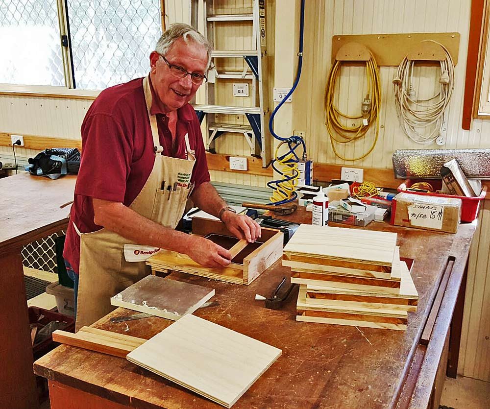 A Shed member assembling a small wooden box at a workbench
