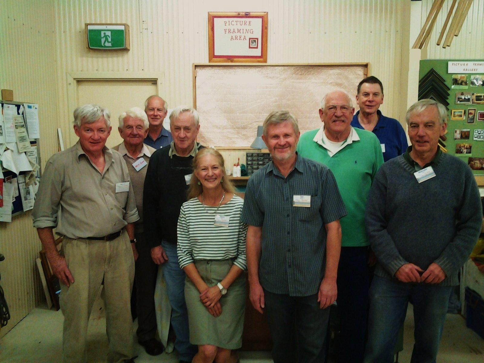 A group of Shed members posing in the Picture Framing Area during a framing class, May 2013