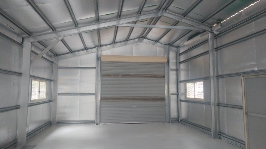 Interior of the completed Block B shell showing steel frame, roller door and windows